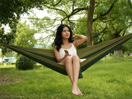 Jeune femme se relaxant confortablement dans un hamac en plein air, parfait pour les moments de détente au soleil