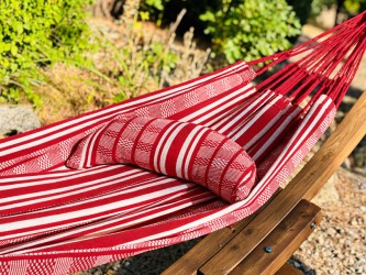 Polygonal red and white fabric cervical pillow, crescent-shaped, on a hammock of the same texture