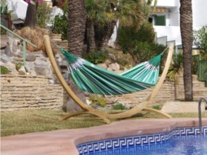 hamac vert avec son support près du piscine
